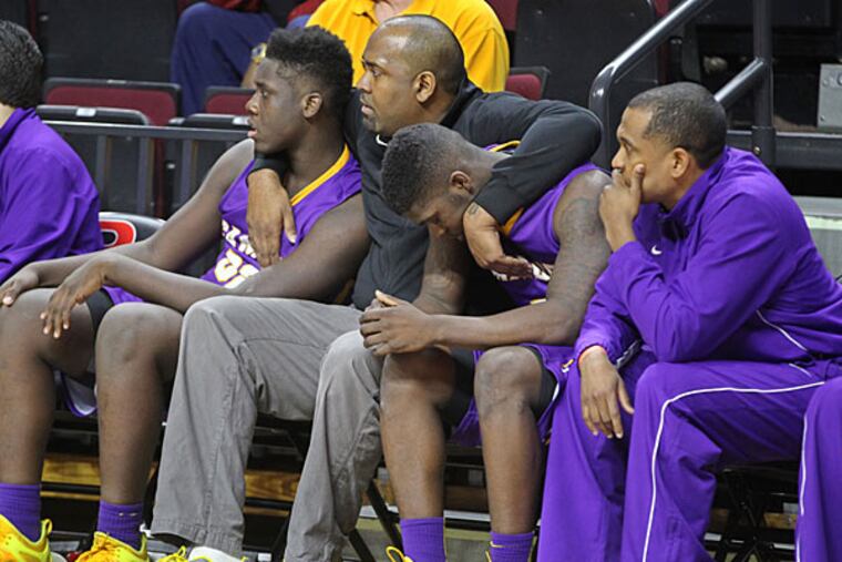 Camden council member at large, Arthur Barclay, center, comforts Camden's #32 Myles Thompson, left, and #1, Brad Hawkins, right, as time winds down on therir season and the loss to Newark Tech 57-51 on Sunday. (Michael Bryant/Staff Photographer)