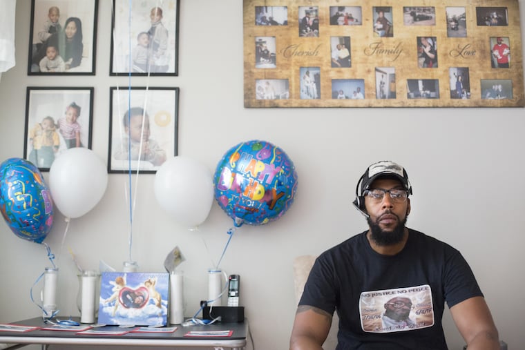 Thomas Jones next to birthday balloons and photos of his family in honor of his son, David Jones', 31st birthday today, in his home in Olney Wednesday, July 26, 2017. Jones was killed after being shot in the back by a police officer.