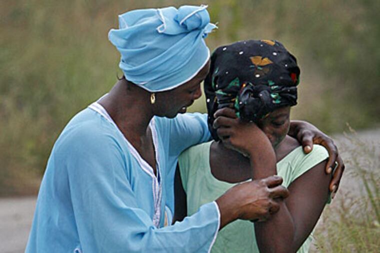Mawa Trawally, left, consoles her daughter Mafata Konneh, 12, the older sister of Madousou Konneh, 9, the young girl that died in the Schuylkill River and whose body was recovered this morning. (Alejandro A. Alvarez / Staff Photographer)