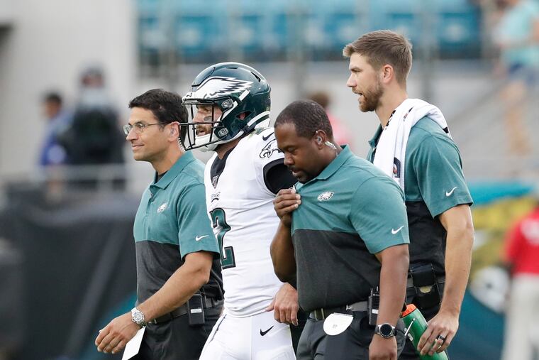 Eagles quarterback Cody Kessler leaves the game with the team medical staff after Kessler got hit by Jacksonville Jaguars defensive end Josh Allen during the first-quarter in a preseason game Thursday, August 15, 2019 in Jacksonville.