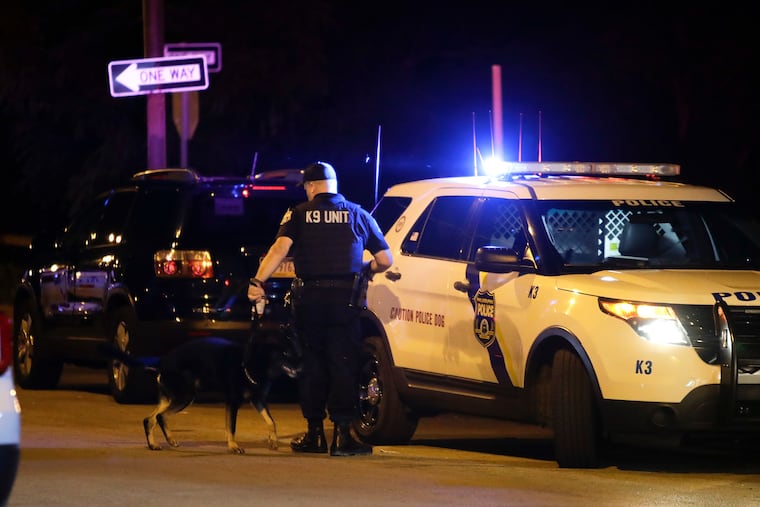 A Philadelphia Police K-9 officer and his dog prepare to look for a suspect near the 2300 block of North Reese Street in North Philadelphia after an officer was grazed in the head by a bullet on Monday, August 23, 2021.