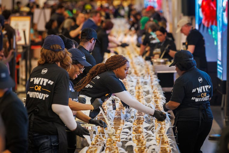Assemblers prepare the cheesesteaks at Philadelphia International Airport Tuesday to attempt to set a Guinness World Record for the longest line of cheesesteaks.