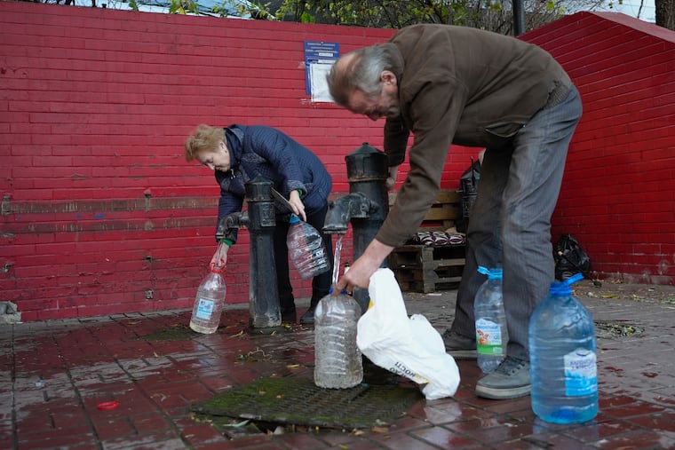 People fill containers with water from public water pumps in Kyiv, Ukraine, on Monday.