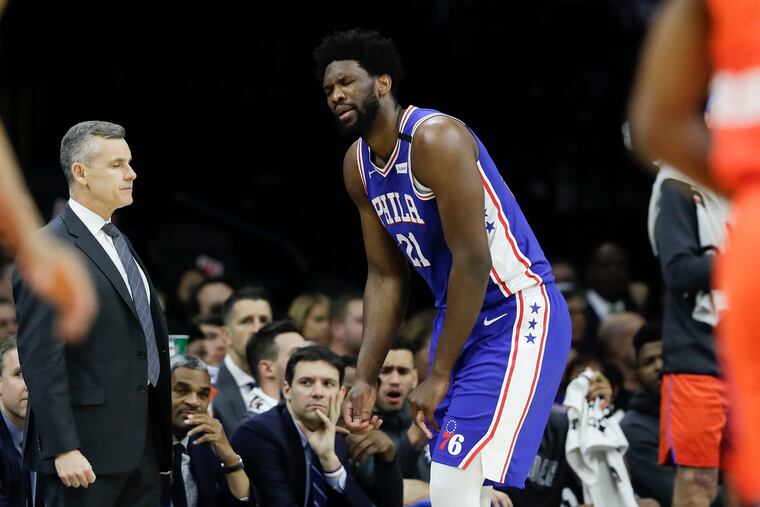 Sixers center Joel Embiid reacts after injuring his finger during the first-quarter next to Oklahoma City Thunder Head Coach Billy Donovan on Monday, January 6, 2020 in Philadelphia.