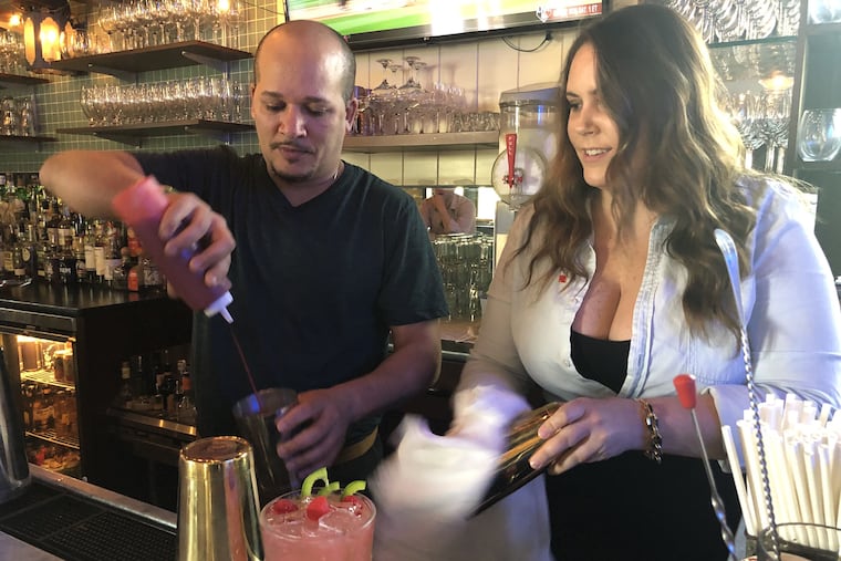 Bartender Anwar Morgan and Michelle Curtis, an account specialist with Campari America, mix a drink at Bar Amis.