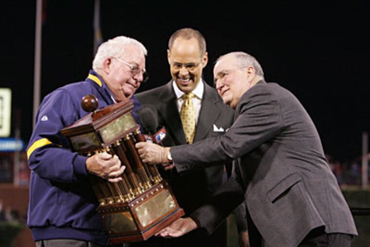 Phillies president David Montgomery (right) and team chairman Bill Giles (left) with TBS' Ernie Johnson at trophy presentation after NLCS Game 5. (David Swanson / Staff Photographer)