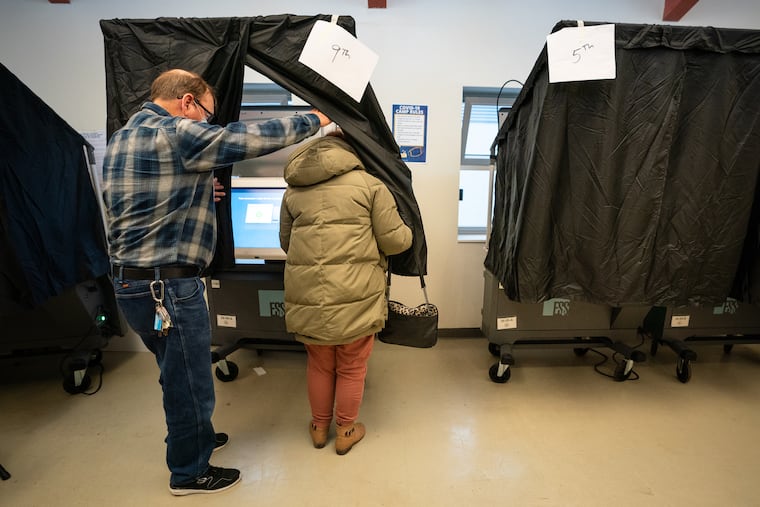 A poll worker assists a voter at a polling place at Barry Playground, in South Philadelphia, on Nov. 3, 2020.