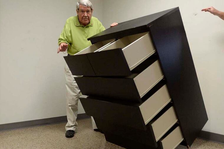 Bobby Puett, of Diversified Testing Labs, watches as the Malm six-drawer dresser falls during testing.