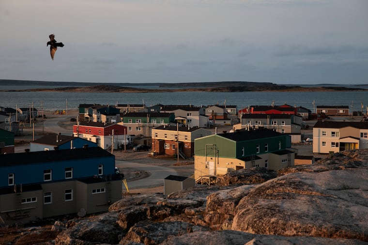 The rising sun illuminates colorful homes on the coastline in Inukjuak, Quebec.