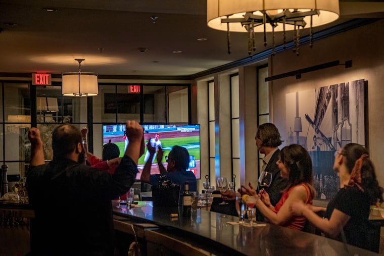 Patrons at Ristorante Panorama in Old City celebrate one of the Phillies many home runs during Game 3 of the World Series, watching on the new TV behind the bar Nov. 1, 2022.