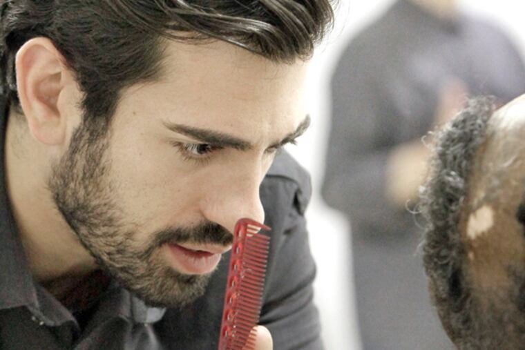Joey Berardi gives a resident a free haircut at the homeless shelter in the basement of the Arch Street United Methodist Church in Philadelphia on April 17, 2014. (ELIZABETH ROBERTSON/Staff Photographer)