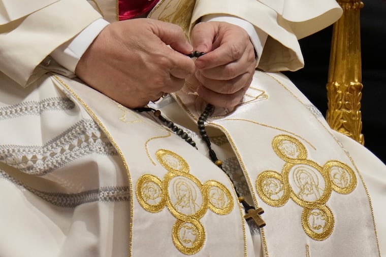 Pope Leo XIV holds a rosary as he leads a vigil for peace inside St. Peter's Basilica at the Vatican on Saturday.