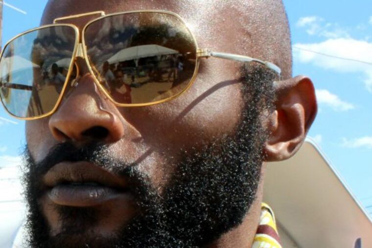 George Raymond, 30, rocks gold framed shades and green kente to the 10th Annual Roots Picnic.