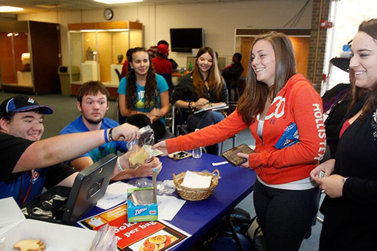 Michele Christy,18 (2nd from right) and Emily Hasselman,18 (right) are buying $1.00 cookies each from Members of the Ghost Chasers Club ( left to right) Justin Reach,19; John Taite,19 ; Marina Mollica,19 and Alex Salvatore,18 at the Gloucester County College. ( AKIRA SUWA / Staff Photographer )