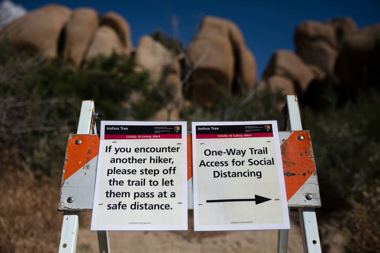 Signs advise visitors to social distance at Joshua Tree National Park in California.