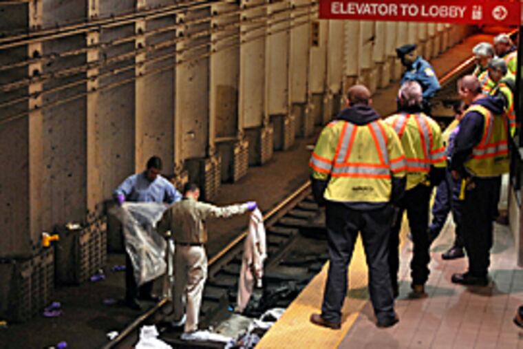 Investigators on the rails today of the westbound track at the PATCO Hi Speed Line Broadway Station in Camden where witnesses said a man jumped in front of a commuter train. (Tom Gralish / Inquirer)