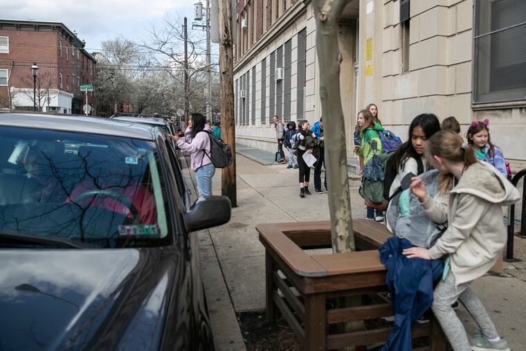 Students wait to be picked up by parents during dismissal at Masterman Public School in Philadelphia on Friday, March 13, 2020. Gov. Tom Wolf announced on Friday that all Pennsylvania schools will close for two weeks amid the outbreak of the coronavirus.