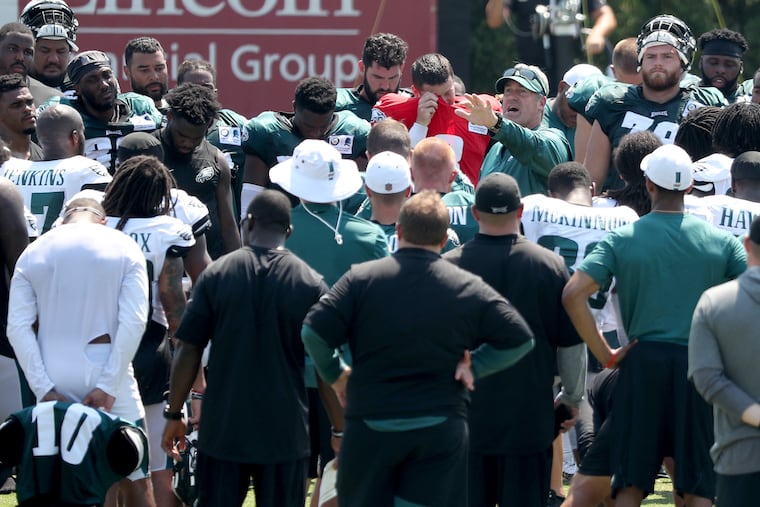 Eagles’ head coach Doug Pederson, center, talks with his players after an Eagles training camp session.