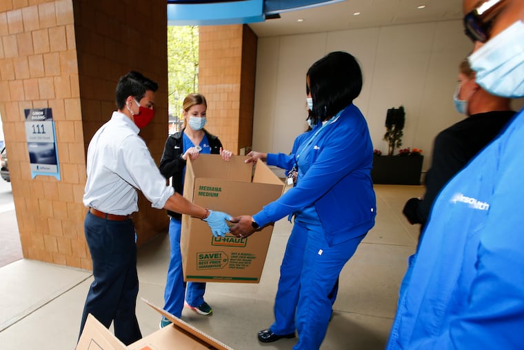 Andre Del Valle (left) a Democratic candidate for Pennsylvania state representative in the 175th district, with a box of food for Thomas Jefferson University Hospital transplant and urology surgery department members.