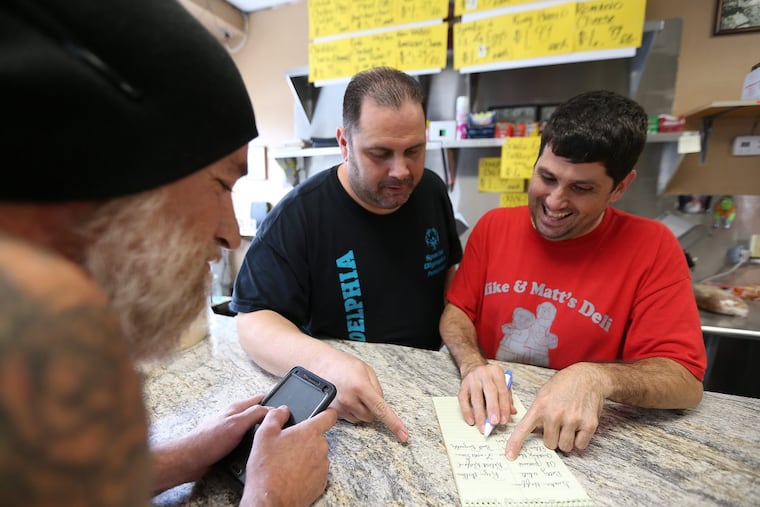 Left to right: Chris Olmi, Gino Caporale, and Mike Silvano talks about their monthly celebrity death pool at Mike & Matt’s deli on October 7, 2017.