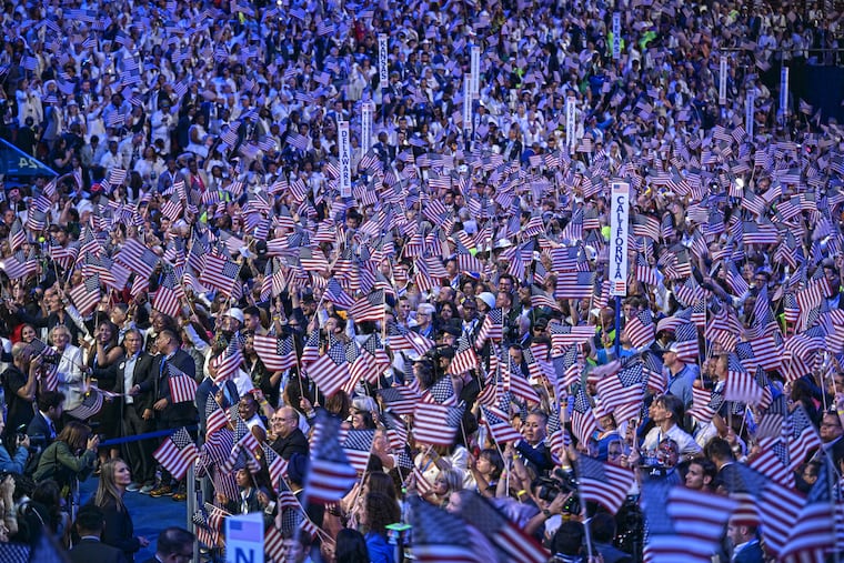 Democrats wave their flags during the Democratic National Convention at the United Center in Chicago on Aug. 22, 2024.
