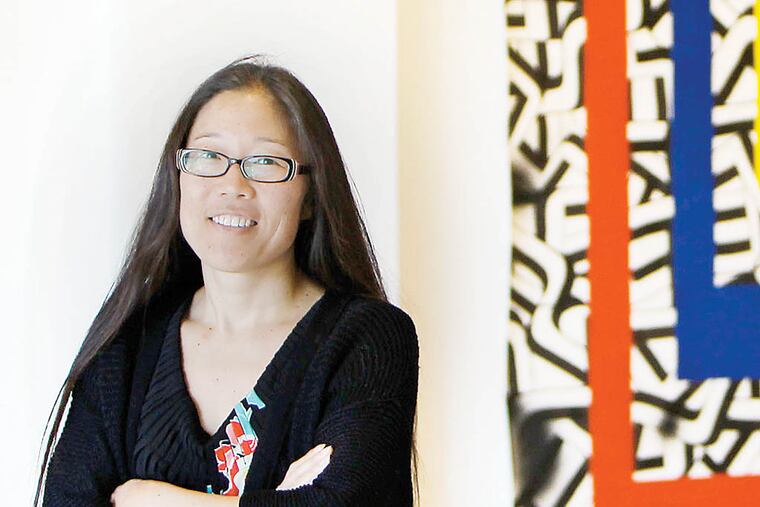 Gayle Isa, director the Asian Arts Initiative in Philadelphia, poses in the gallery space on September 17, 2013. ( DAVID MAIALETTI / Staff Photographer )