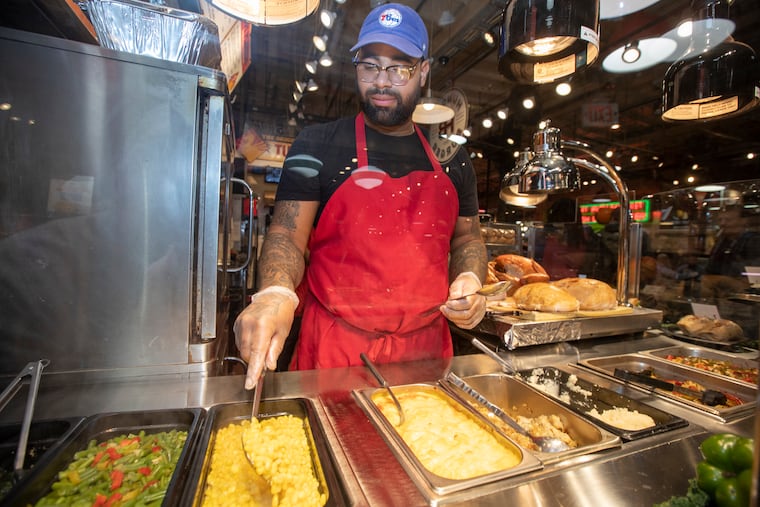 Mac Ozuna, the manager of The Original Turkey in the Reading Terminal Market, stirs the cream corn they have as a side for their turkey dishes, along with mac and cheese, mashed potatoes , stuffing and green beans.