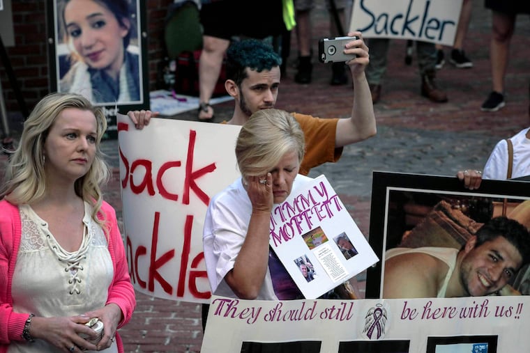 FILE - Protesters who have lost love ones to the opioid crisis protest outside a courthouse in Boston, Aug. 2, 2019, where a judge heard arguments in a lawsuit against Purdue Pharma.