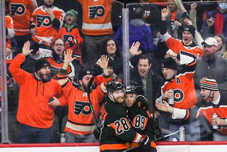 Flyers right wing Cam Atkinson celebrates with center Claude Giroux after a goal in the third period of a game against the Los Angeles Kings at the Wells Fargo Center in South Philadelphia on Saturday, Jan. 29, 2022.