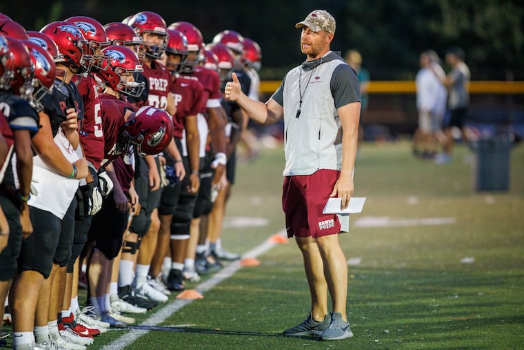 Head coach Tim Roken with players at the start of practice on Aug. 22 at Brady Field.
