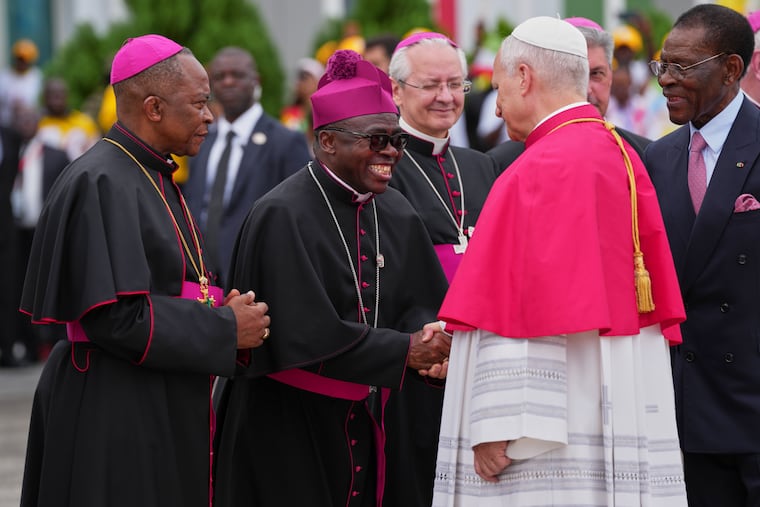 Pope Leo XIV, flanked by Equatorial Guinea's President Teodoro Obiang Nguema Mbasogo (right), is welcomed by Archbishop Juan Nsue Edjang Mayé (left) and Juan Domingo-Beka Esono Ayang upon his arrival Tuesday at Malabo International Airport.