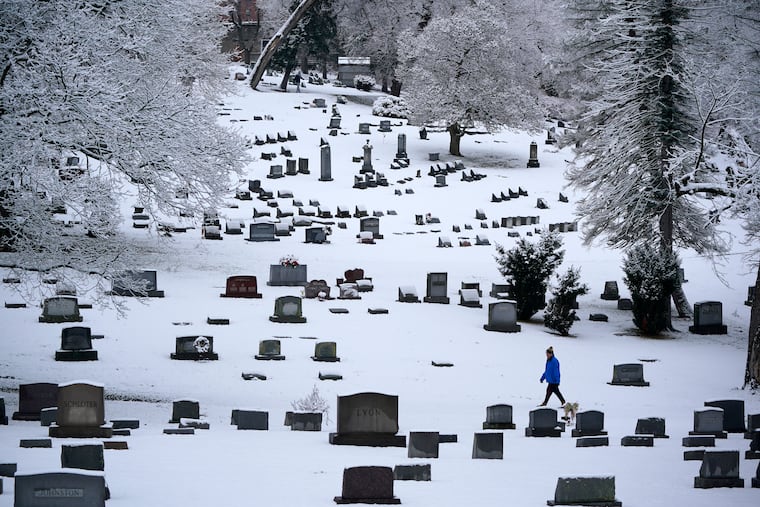 A man walks through the snow covered Mount Lebanon Cemetery in Mount Lebanon in January. U.S. deaths fell in 2022, as COVID-19 fatalities dropped by half from 2021 and the coronavirus dropped from being the nation's third leading cause of death to the fourth.