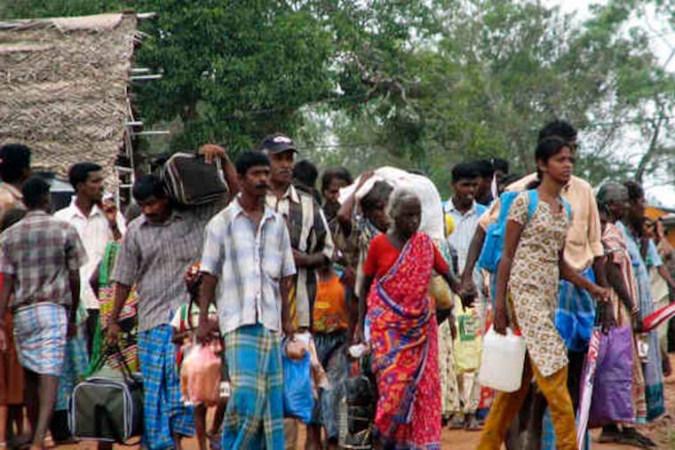 Ethnic Tamils leave camps for displaced persons in Manik Farm, Sri Lanka. After the war ended, the government herded civilians into the camps, which are to be closed by the end of January.