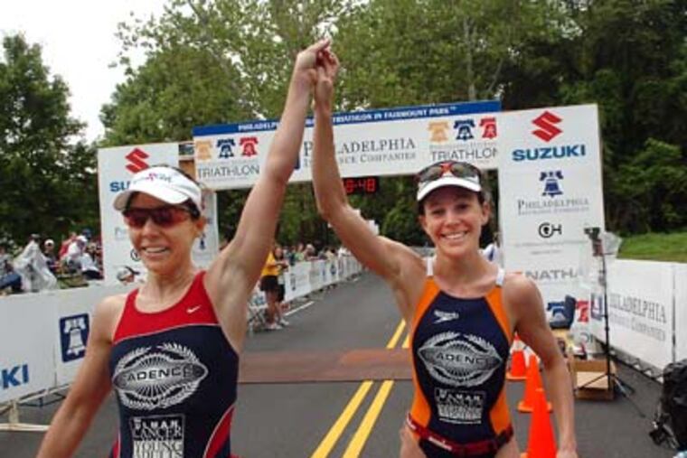 Rebeccah Wassner (right) won the women's Philadelphia Insurance Triathlon for the second year in a row, and walks arms raised with her twin sister Laurel Wassner as Laurel she finishes the race in third place for the women. (Sharon Gekoski-Kimmel / Inquirer) June 22, 2008. Editors Note: Triathlon23 4/8