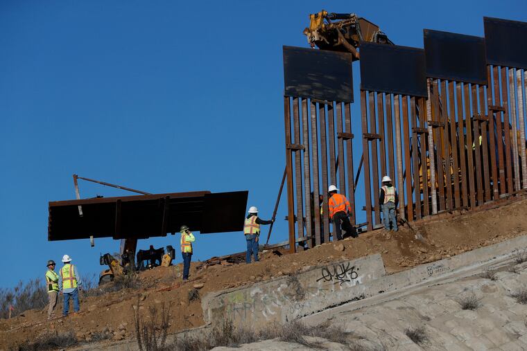 Workers add new sections to the U.S. border wall, seen from Tijuana, Mexico, Saturday, Dec. 8, 2018. Discouraged by the long wait to apply for asylum through official ports of entry, many Central American migrants from recent caravans are choosing to cross the U.S. border wall illegally and hand themselves in to border patrol agents. (Rebecca Blackwell / AP)