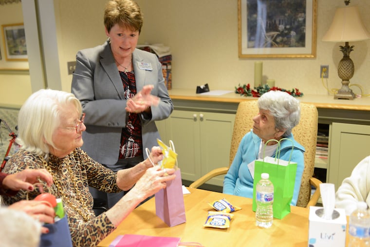 From left, Helen Adams places items into a welcome bag as she speaks with Kelly Carney, corporate director of memory care services for Acts Retirement-Life Communities, center, and Marilyn Jacobs. The bags were for new residents at Spring House Estates in Lower Gwynedd. The hands-on task reflected Acts' new certification in Montessori techniques.
