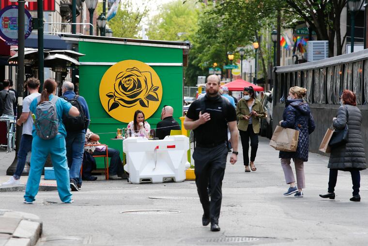 Diners at El Vez sit outside while pedestrians stroll along 13th Street in the Midtown Village neighborhood on Friday.