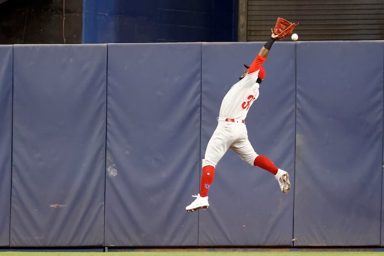Phillies center fielder Odubel Herrera can't come up with a drive by the Marlins' Miguel Rojas during the first inning.