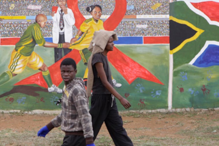 Pedestrians pass a mural promoting safe sex in Soweto, South Africa, before World AIDS Day. (Denis Farrell / AP Photo)