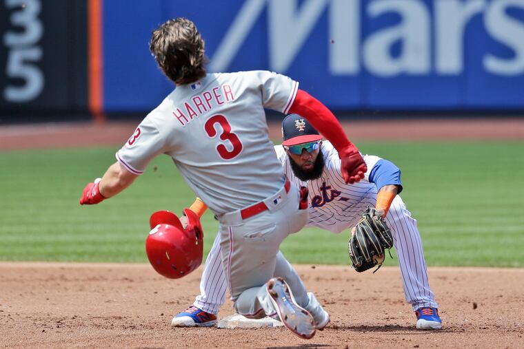 Phillies outfielder Bryce Harper gets tagged out at second base by Mets shortstop Amed Rosario on July 7 at Citi Field in New York. Since that game, the Phillies have been passed by the Mets in the standings.
