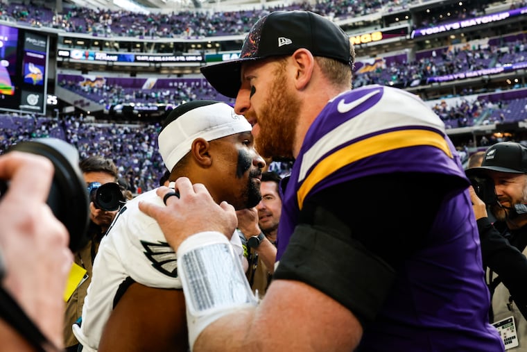 Jalen Hurts greets Carson Wentz following Sunday's game in Minnesota.