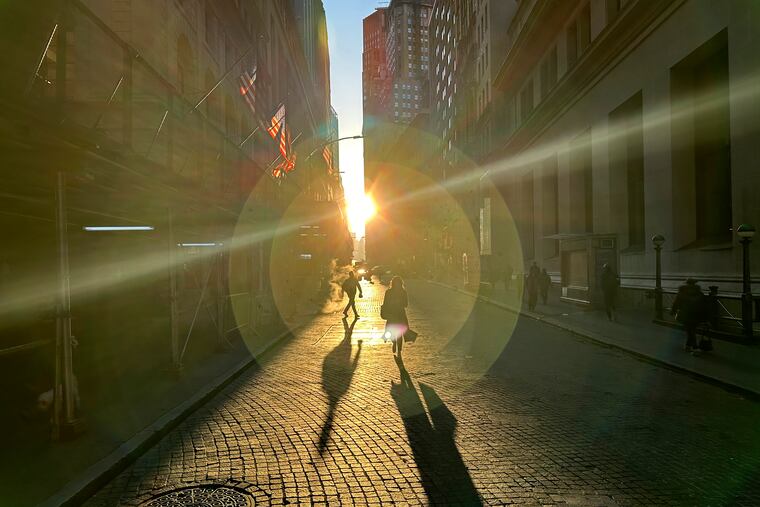People walk on Wall Street in New York's Financial District on Wednesday, Dec. 18, 2024.