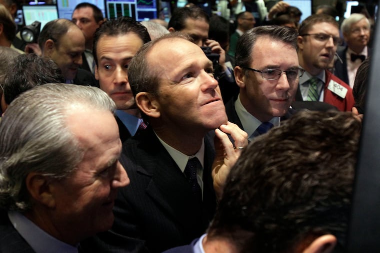 Then-Nielsen Company CEO David Calhoun, center, watches progress as he waits for the company's IPO to begin trading in 2011 on the floor of the New York Stock Exchange.