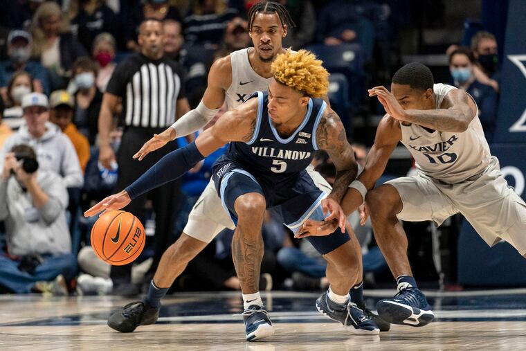 Xavier's Nate Johnson (10) attempts to steal the ball from Villanova's Justin Moore during the first half in Cincinnati.
