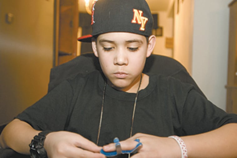 Jonathan Rojas looks at the finger broken last fall during a fight at Woodrow Wilson Middle School in the Northeast. The school didn't call police until the day after the assault, which angers Rojas' mother. (Ron Tarver/Staff)