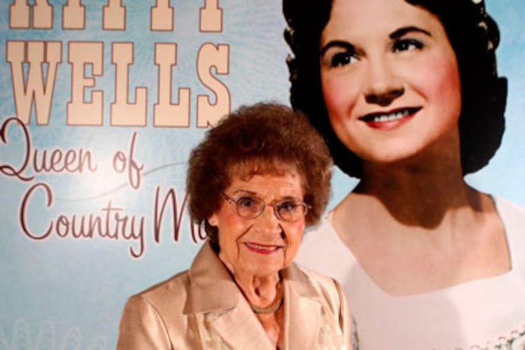 FILE - This Aug. 14, 2008 file photo originally released by the Country Music Hall of Fame and Museum shows music pioneer Kitty Wells at an exhibit honoring her career in Nashville, Tenn. Wells, the first female superstar of country music, has died at the age of 92. The singer’s family says Wells died at her home Monday after complications from a stroke. Her recording of "It Wasn't God Who Made Honky Tonk Angels" in 1952 was the first No. 1 hit by a woman soloist on the country music charts. Other hits included "Making Believe" and a version of "I Can't Stop Loving You." (AP Photo/Country Music Hall of Fame and Museum, Donn Jones, file)