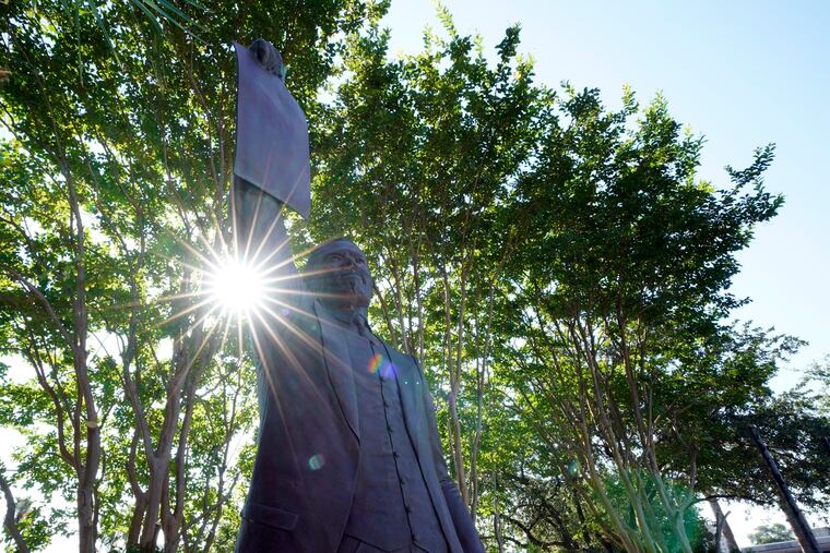 A statue depicting a man holding the state law that made Juneteenth a state holiday in Galveston, Texas.
