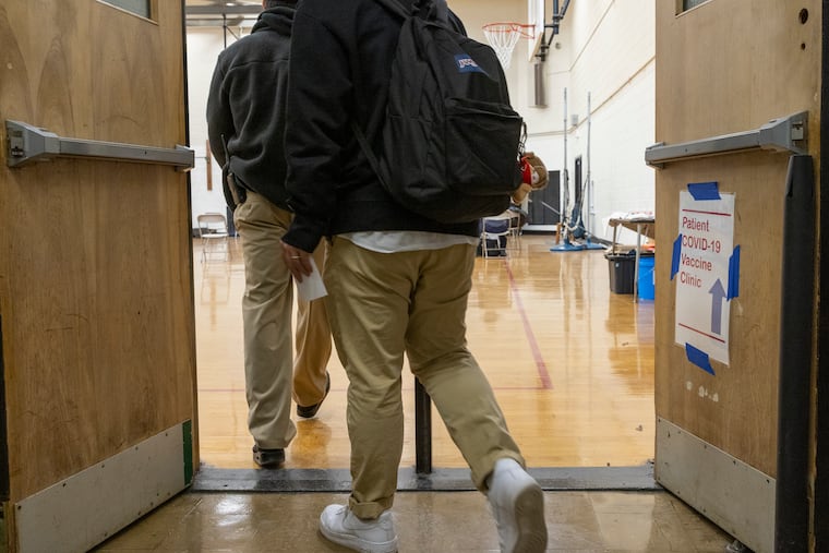 Students arrive to the Northeast High gym to receive COVID vaccines in February. The Philadelphia School District still requires student athletes to be vaccinated, but now allows players from some - but not all - teams to apply for religious or medical exemptions and still participate. Athletes who play outdoor sports can use exemptions, but those who play indoor sports cannot.