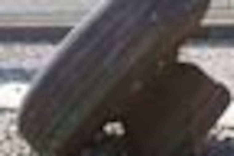 A truck tire lands on a roof of the PHA's Union Training Center on the 1900 block of Vare Avenue in Philadelphia, Pa. on October 22, 2012. ( DAVID MAIALETTI / Staff Photographer )