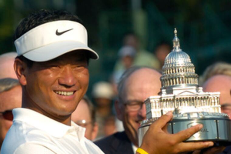 K.J. Choi holds the trophy after winning the inaugural AT&T National golf tournament.